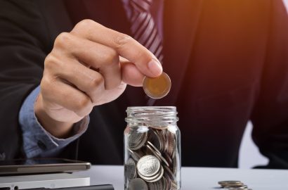 Hand putting mix coins and seed in clear bottle and copyspace, Business investment growth concept.